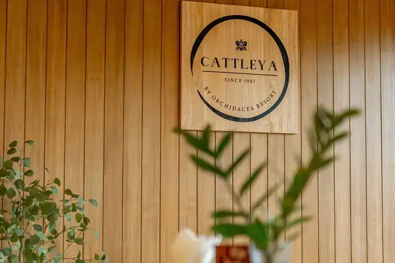 The wooden sign on the slatted timber wall: Cattleya, since 1987, by Orchidacea Resort