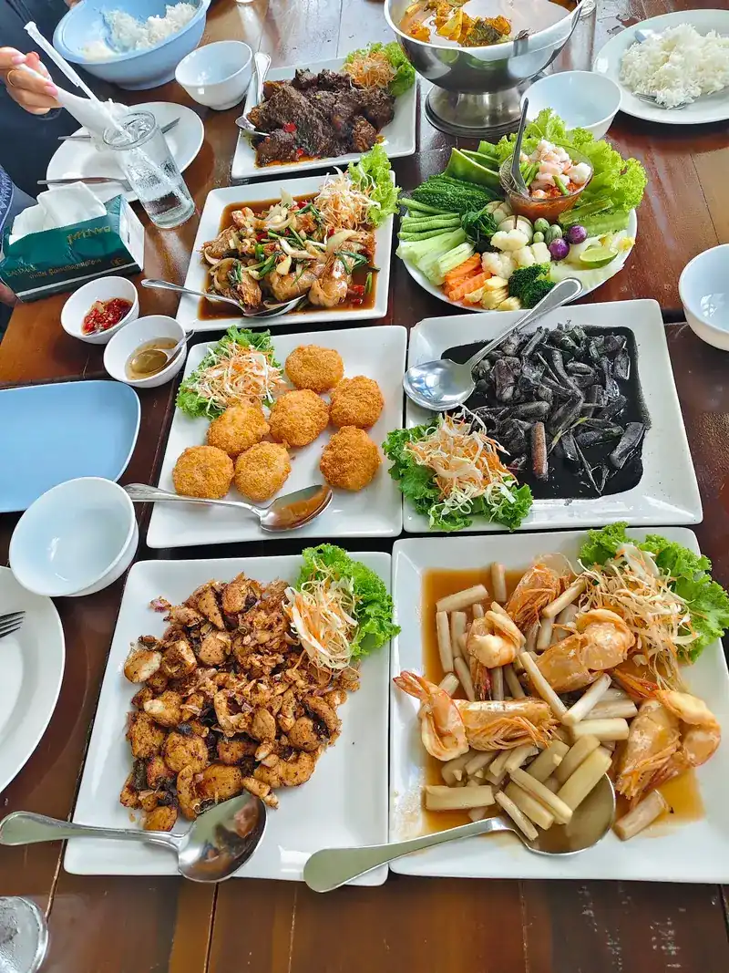 A table spread: squid in black ink, prawns, golden fried cakes and crisp fried morsels
