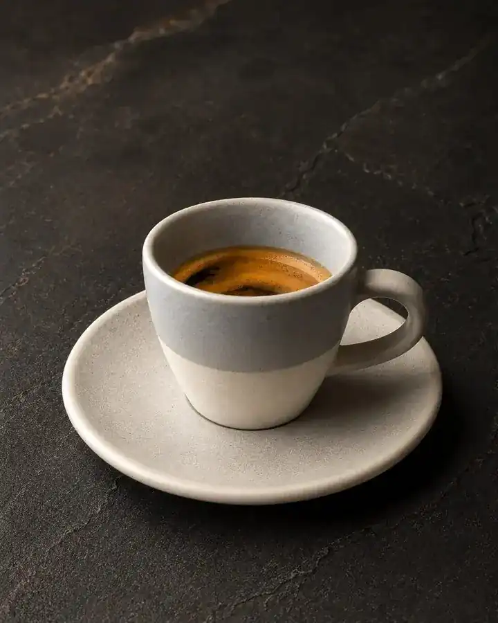Espresso in a grey and white cup on a saucer