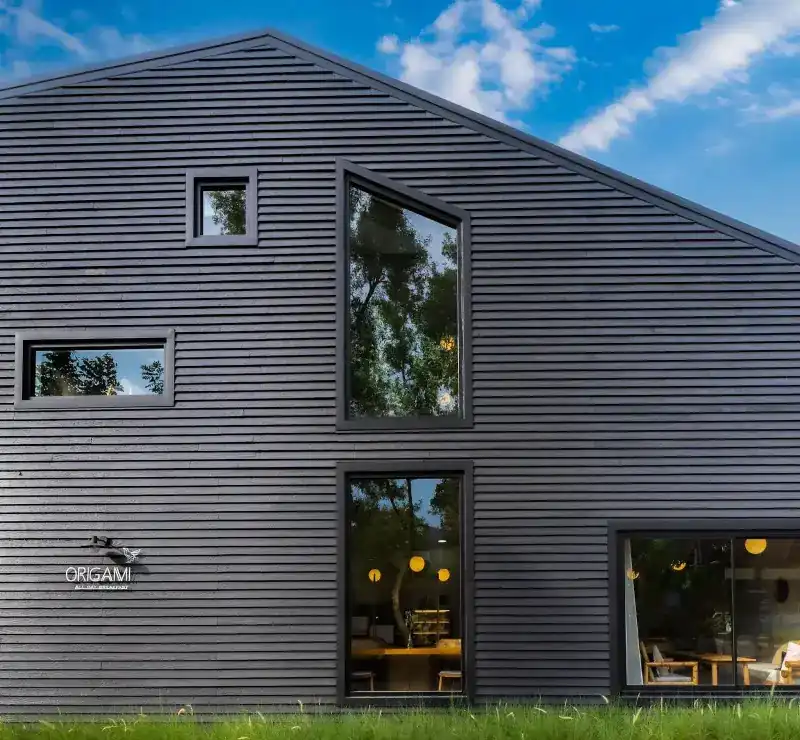 The café's black timber house with its angled windows and the Origami sign