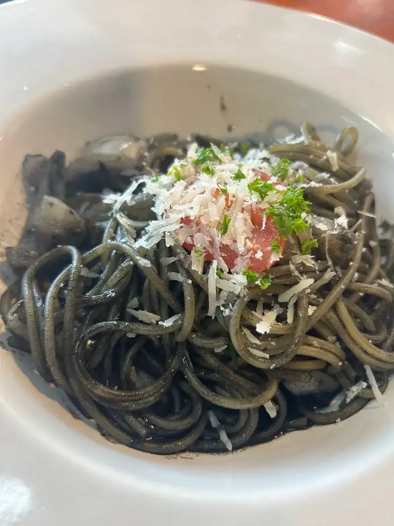 Squid ink spaghetti topped with grated cheese