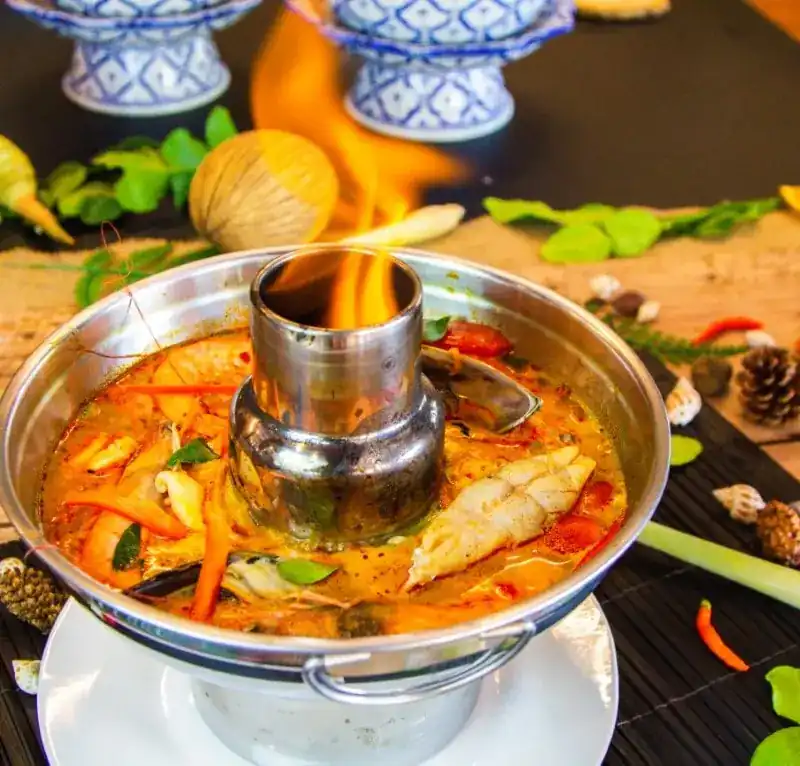 Tom yum hot pot with seafood, flame rising from the chimney