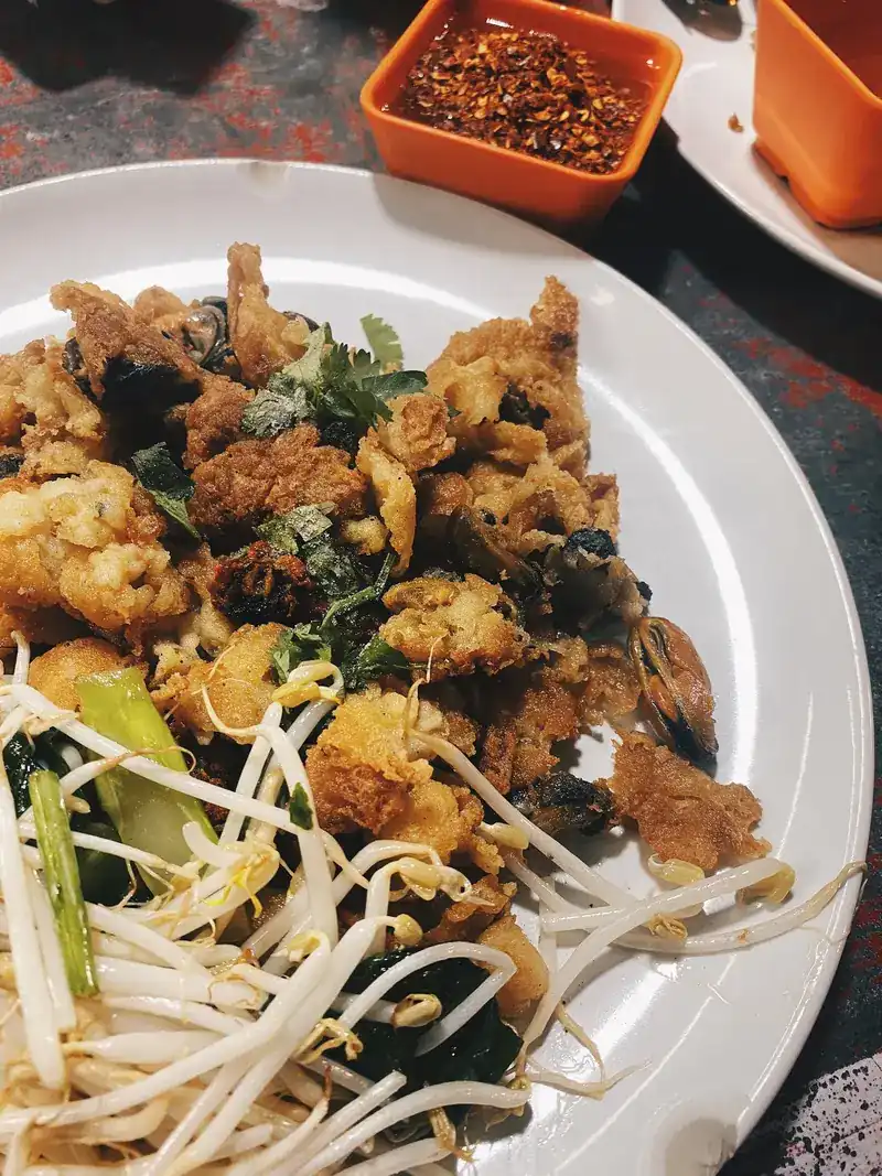 Crisp oyster omelette with bean sprouts and chilli flakes on the side