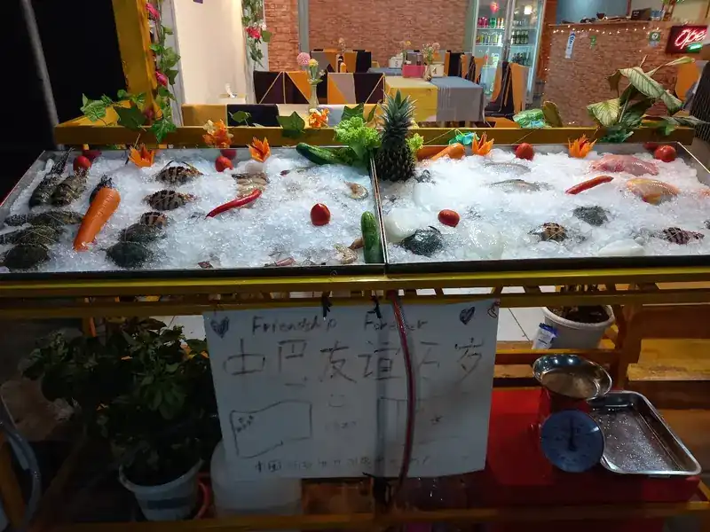 The seafood counter on ice, with a weighing scale beside it / ตู้อาหารทะเลบนน้ำแข็ง มีตาชั่งวางอยู่ข้าง ๆ