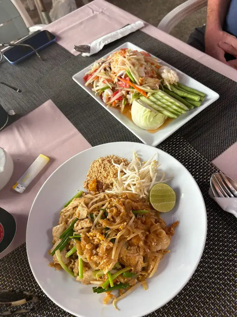 Pad thai with lime and bean sprouts, and a plate of green papaya salad