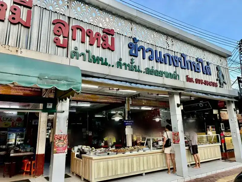 The shop front: a silver sign with big red letters over a long food counter