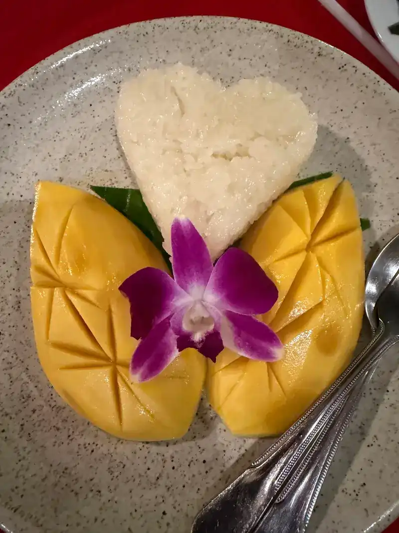 Mango with sticky rice shaped as a heart, with an orchid