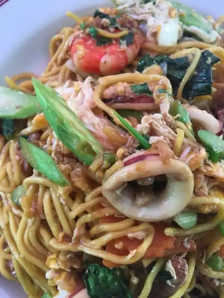 Yellow noodles fried with squid, prawns and green vegetables