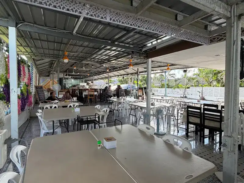 The long covered dining hall, with rows of tables under a metal roof