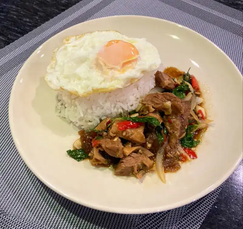 Beef stir-fried with basil and chilli on rice, topped with a fried egg