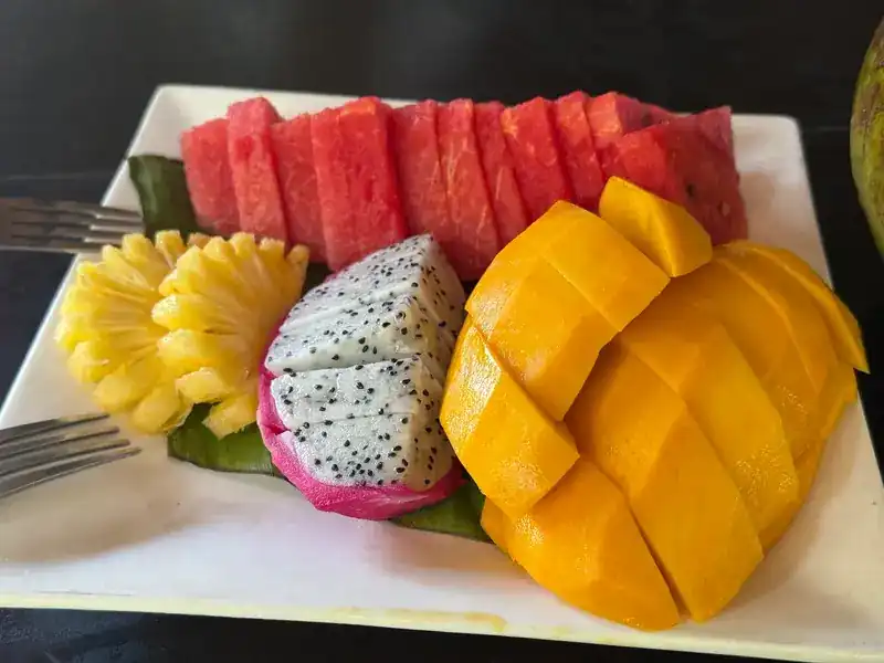 A plate of watermelon, pineapple, dragon fruit and mango