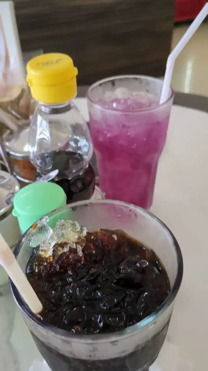 Iced drinks on the table, one purple and one dark with jelly