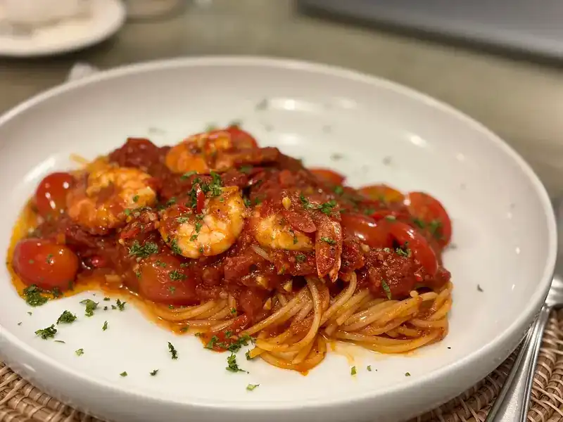 Spaghetti with prawns and cherry tomatoes in tomato sauce