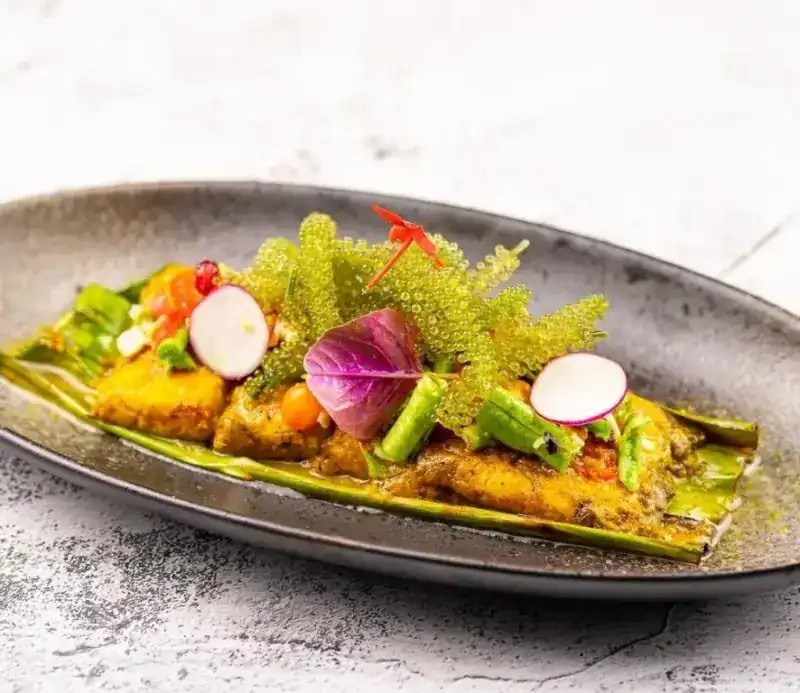 Marinated sea bass on banana leaf with sea grapes