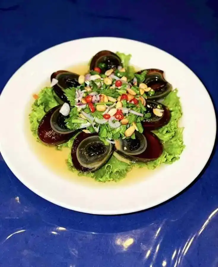 Century egg salad with chilli, shallot and peanuts on lettuce