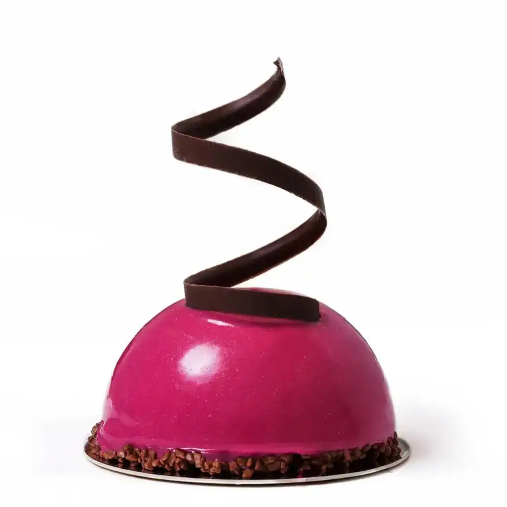 A glazed pink dome pastry topped with a dark chocolate spiral