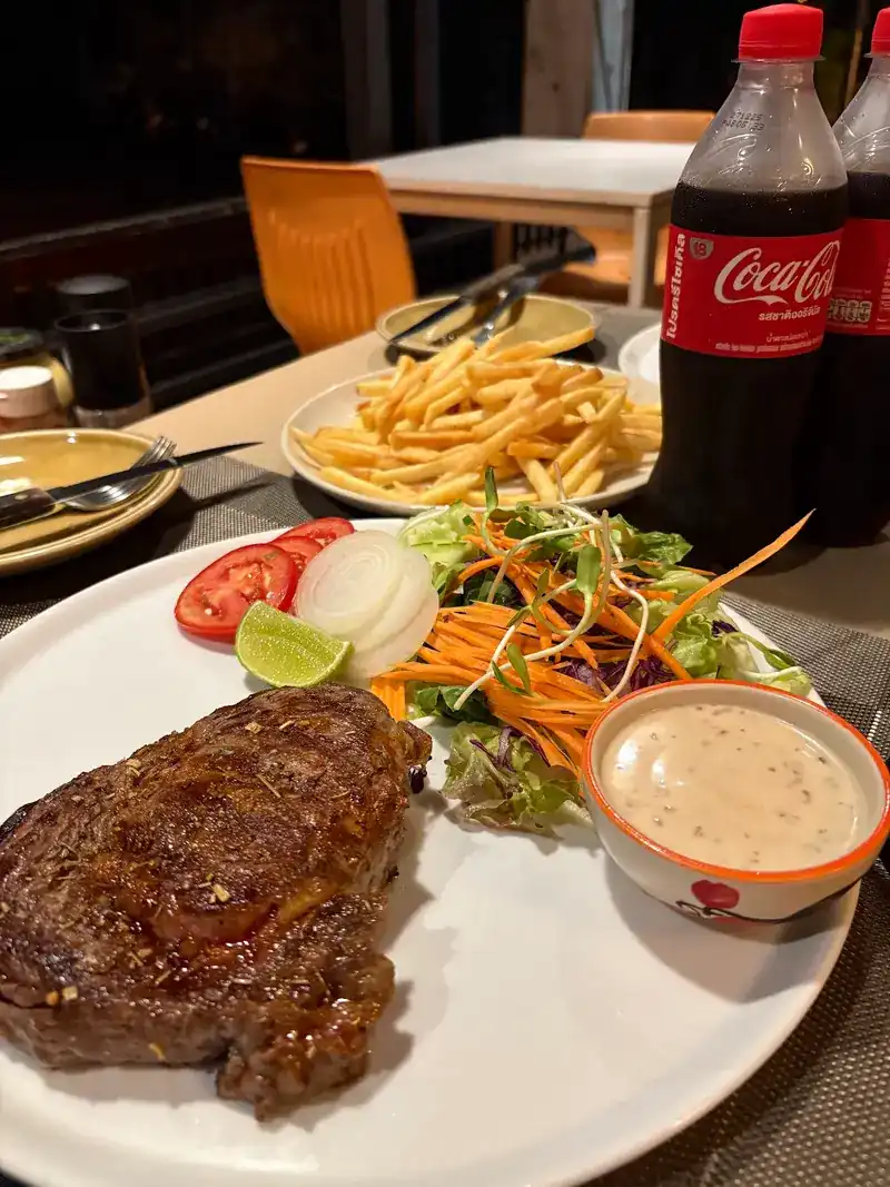 Grilled steak with salad, fries and a creamy sauce