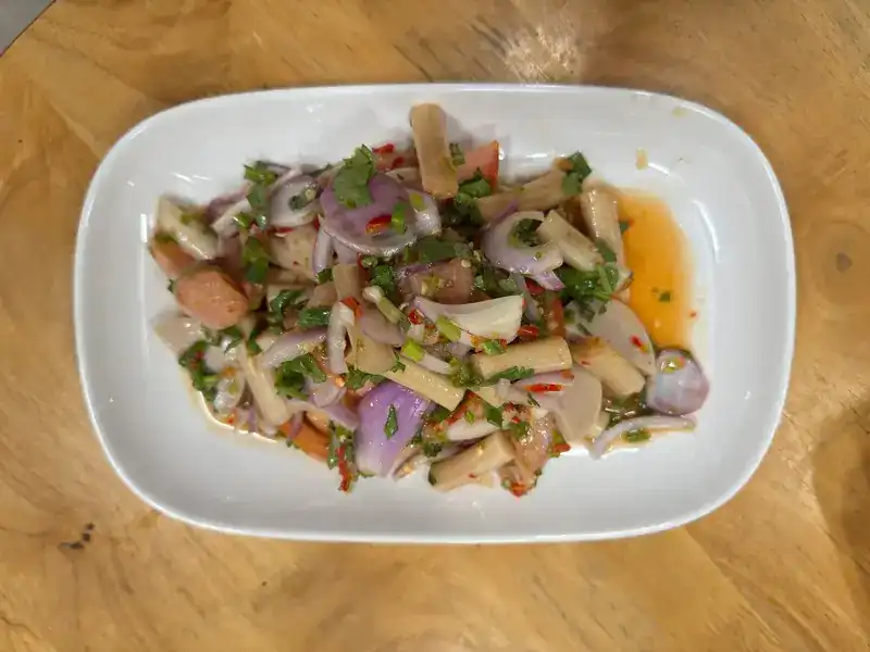 A spicy yam salad with shallots and herbs on a white plate
