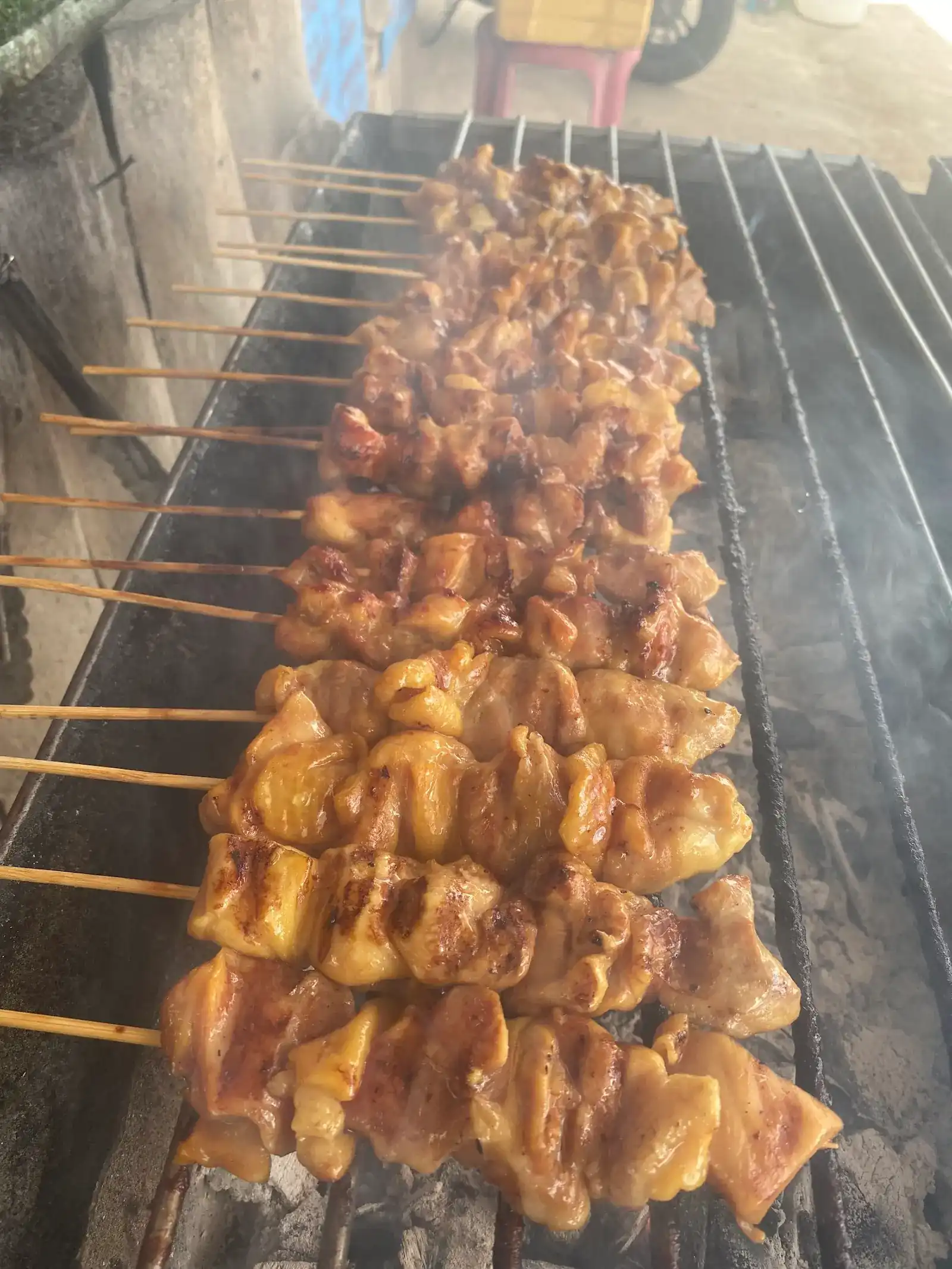 Chicken skewers lined up on the charcoal grill