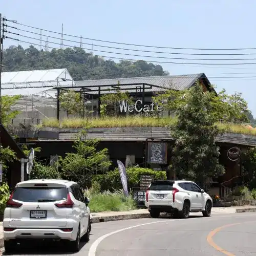 The Sam Kong café with a greenhouse on its roof and a wooded hill behind