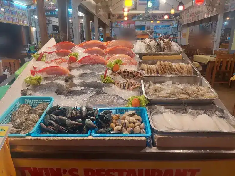 Fish, prawns, lobsters, squid, oysters, mussels and clams laid out on ice