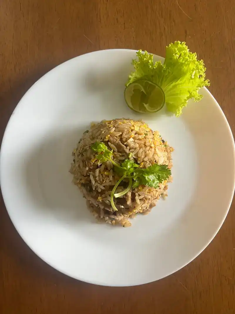 A plate of fried rice with lime and lettuce