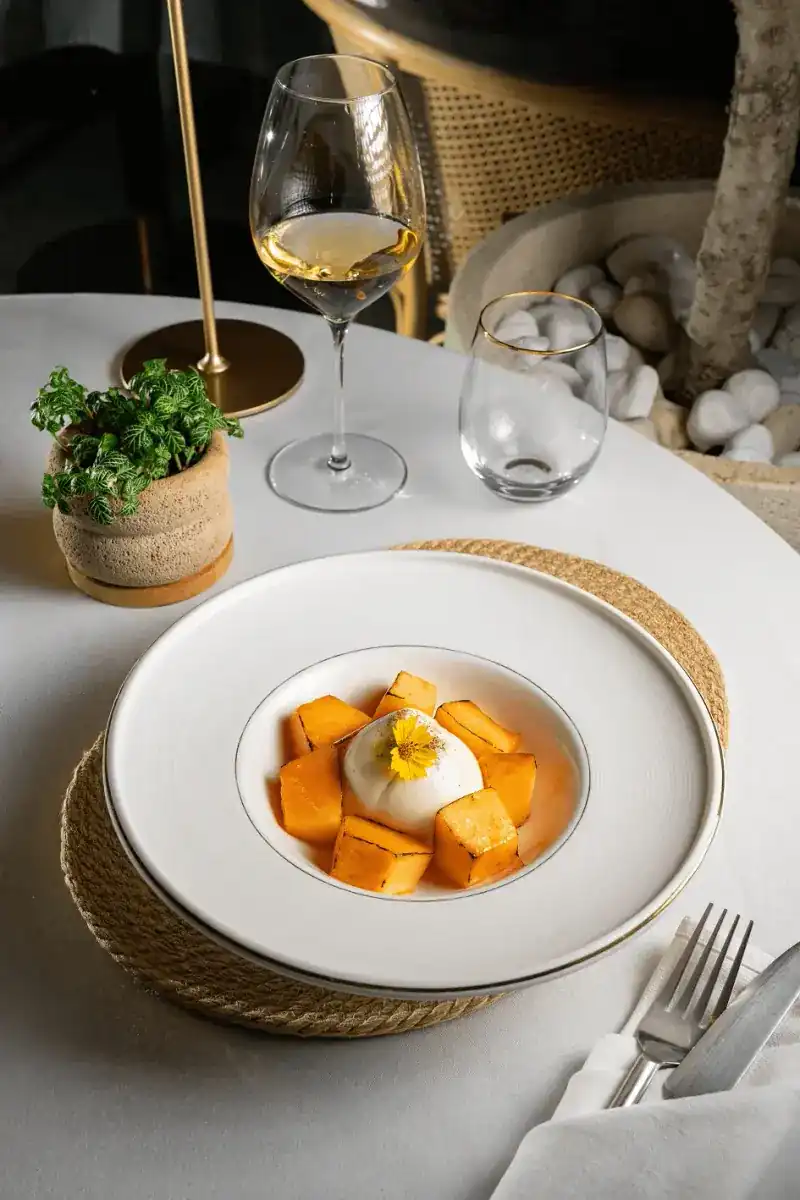 Burrata with grilled melon cubes and a yellow flower