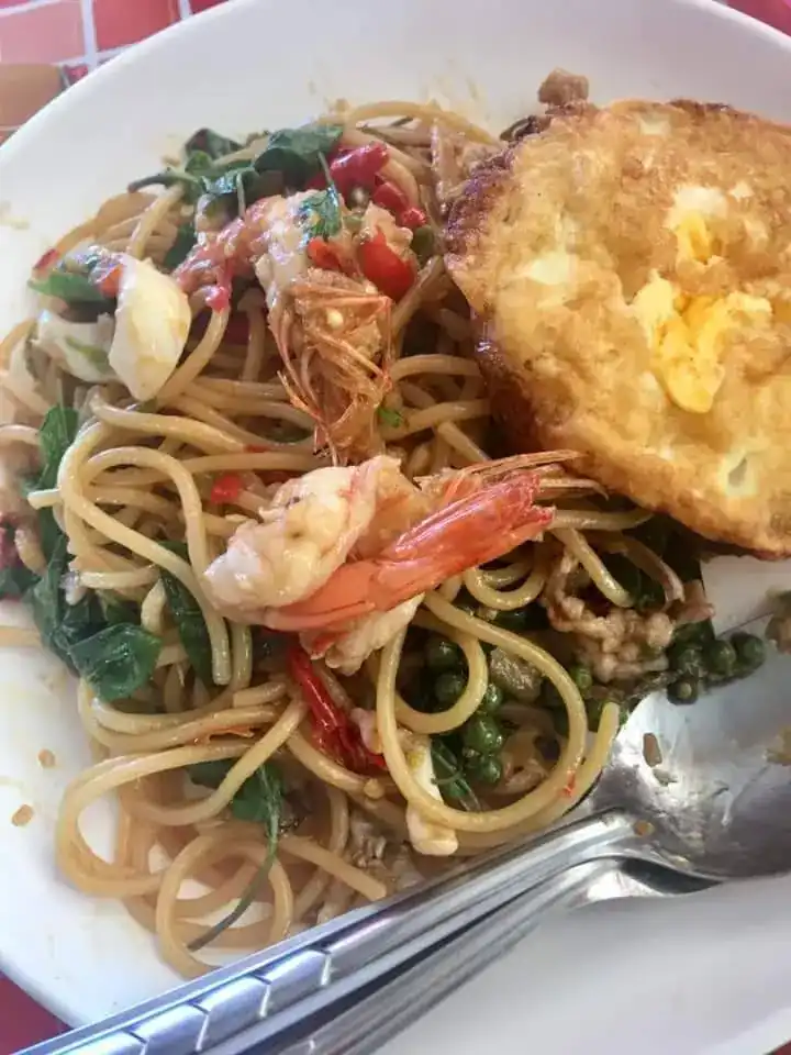 A plate of spaghetti fried with prawns and chilli, a fried egg alongside