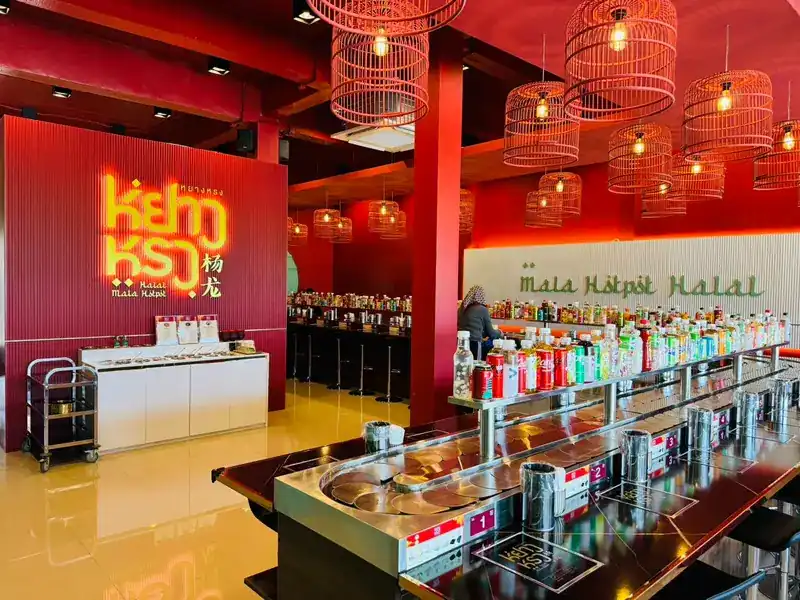 The counter curving round on itself, numbered seats, bottled drinks on the top rail and the restaurant's sign on the red wall