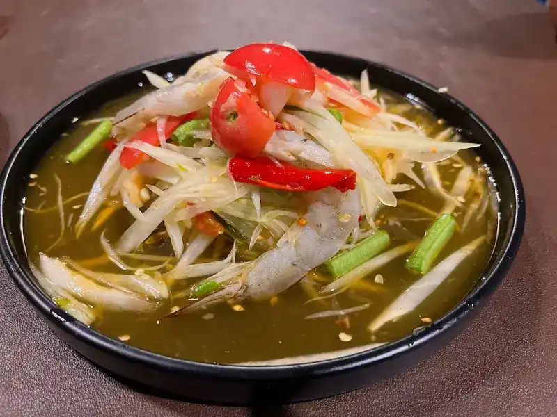 Papaya salad topped with prawns, tomato, red chilli and long beans
