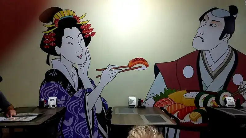 Mural of a geisha lifting a piece of salmon nigiri with chopsticks beside a stern samurai with a platter of sushi, above the dining tables
