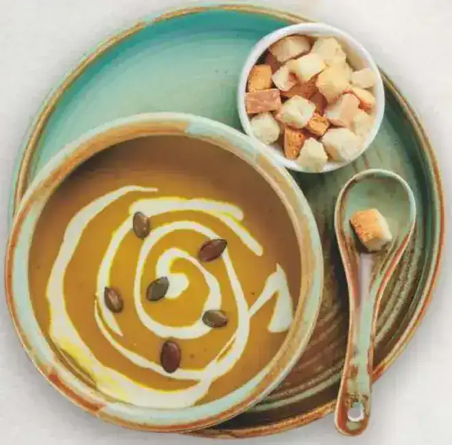 Pumpkin velouté with a swirl of cream and croutons