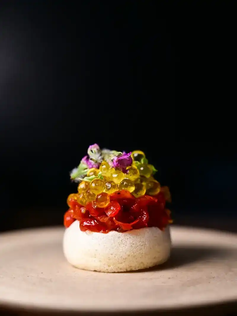 A small course layered in red and gold with tiny flowers, against a dark background