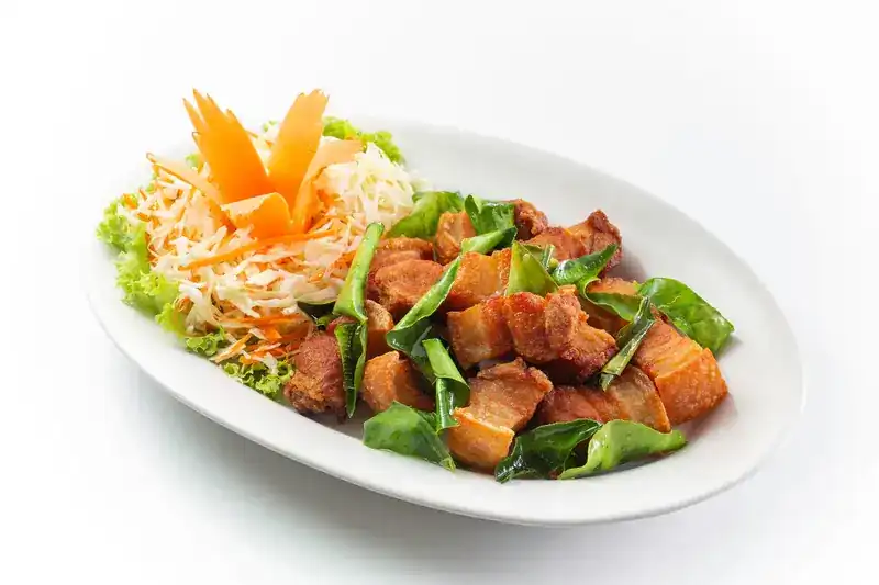 Crispy pork fried with green leaves