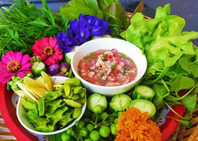 Another tray of nam phrik: a bowl of chilli dip with winged beans, pea aubergines, cucumber, lettuce, zinnias, butterfly pea and a marigold