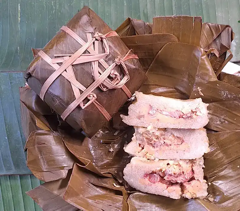 A banana-leaf parcel tied with bamboo strips, and another opened and sliced