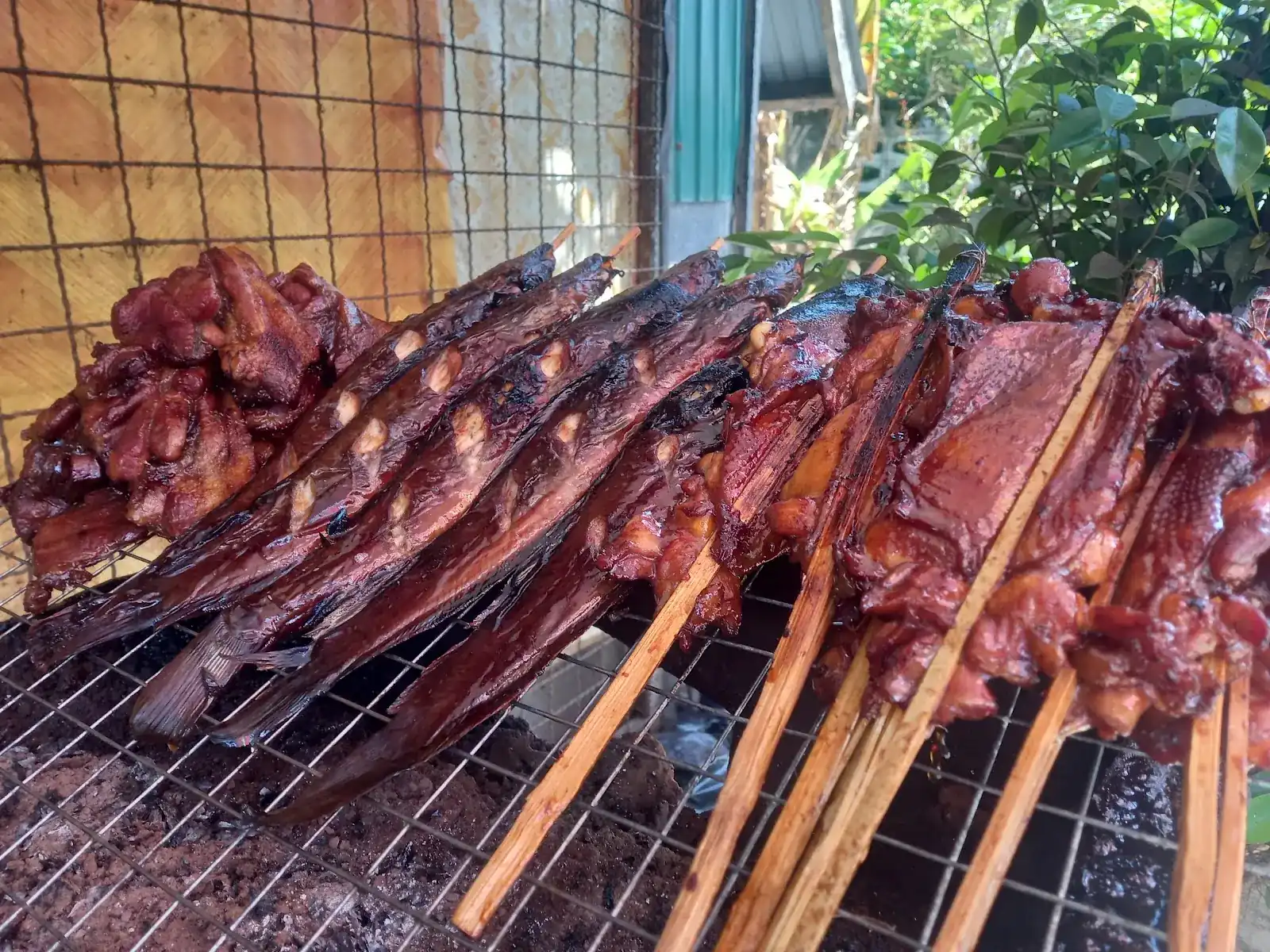 Chicken and meat on bamboo skewers over a charcoal grill