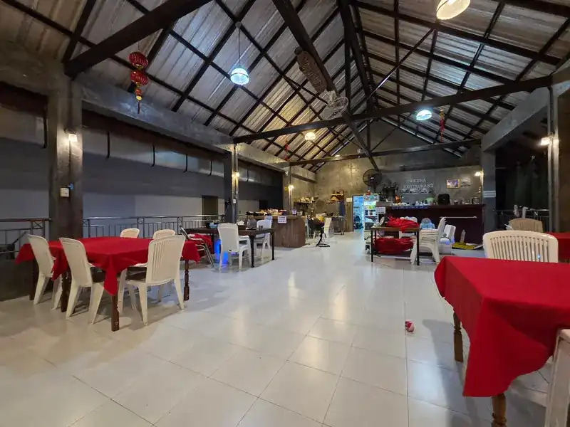 The hall with its high roof, red tables and white tiled floor