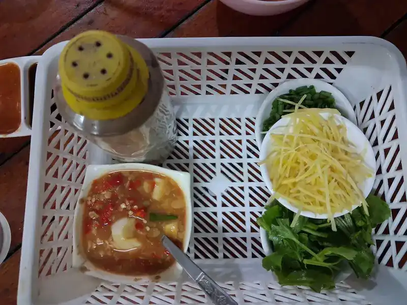 Ginger, greens and a chilli dip in the basket on the table