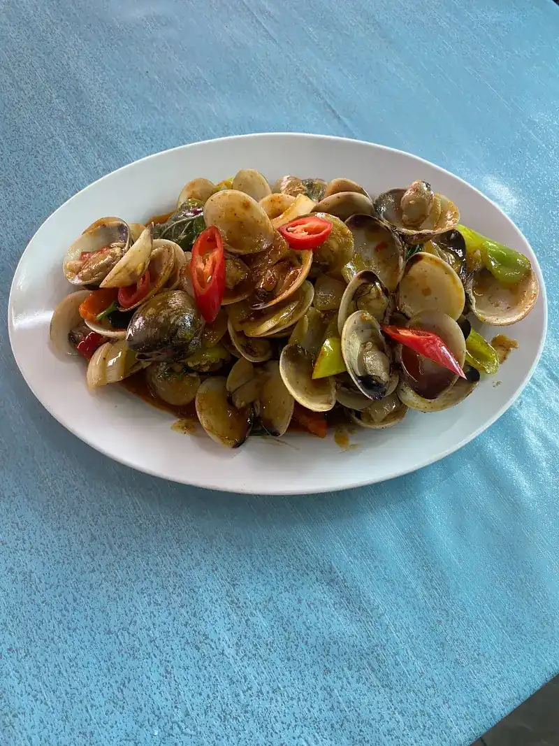 Clams stir-fried with red and green chillies on an oval plate
