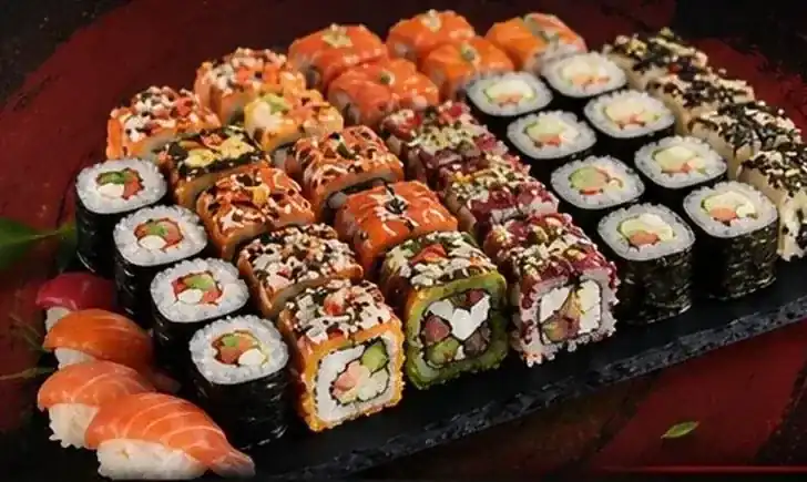 A slate board of ThaiNuki rolls, maki and salmon nigiri