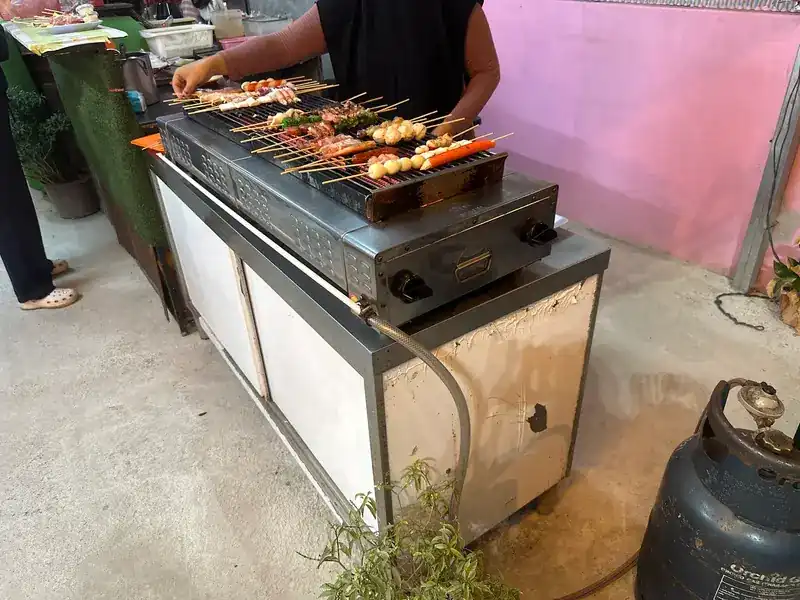 Skewers being turned on a gas grill