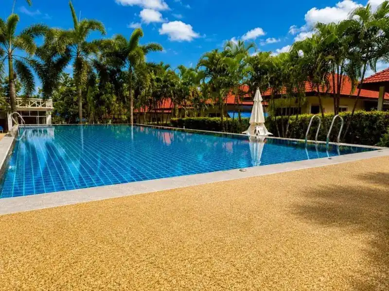 The pool on a sunny day with bungalows behind
