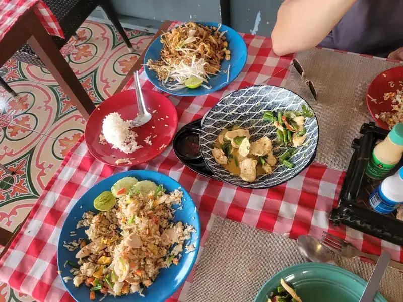 Pad thai, fried rice and a stir-fry on a red-check tablecloth
