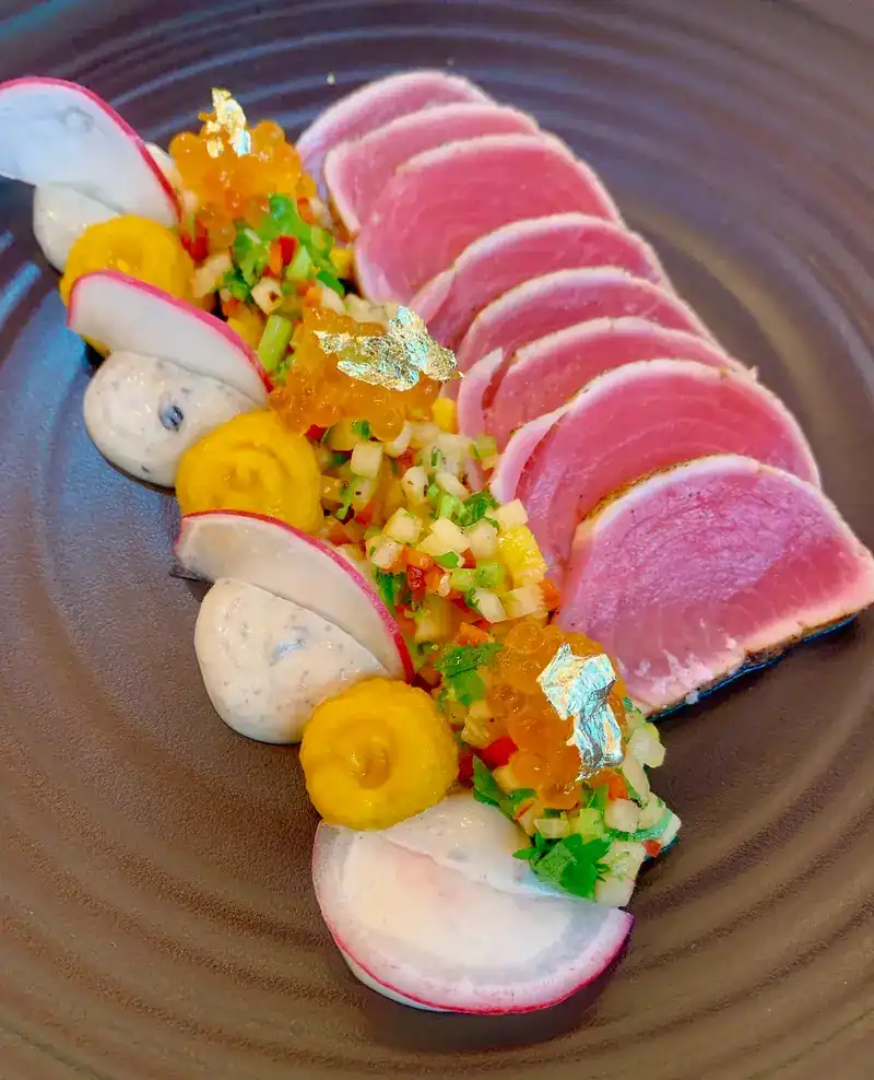 Seared tuna slices with gold leaf, radish and salmon roe