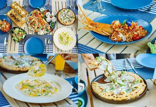 Seafood, pasta and pizzas on blue plates and striped placemats