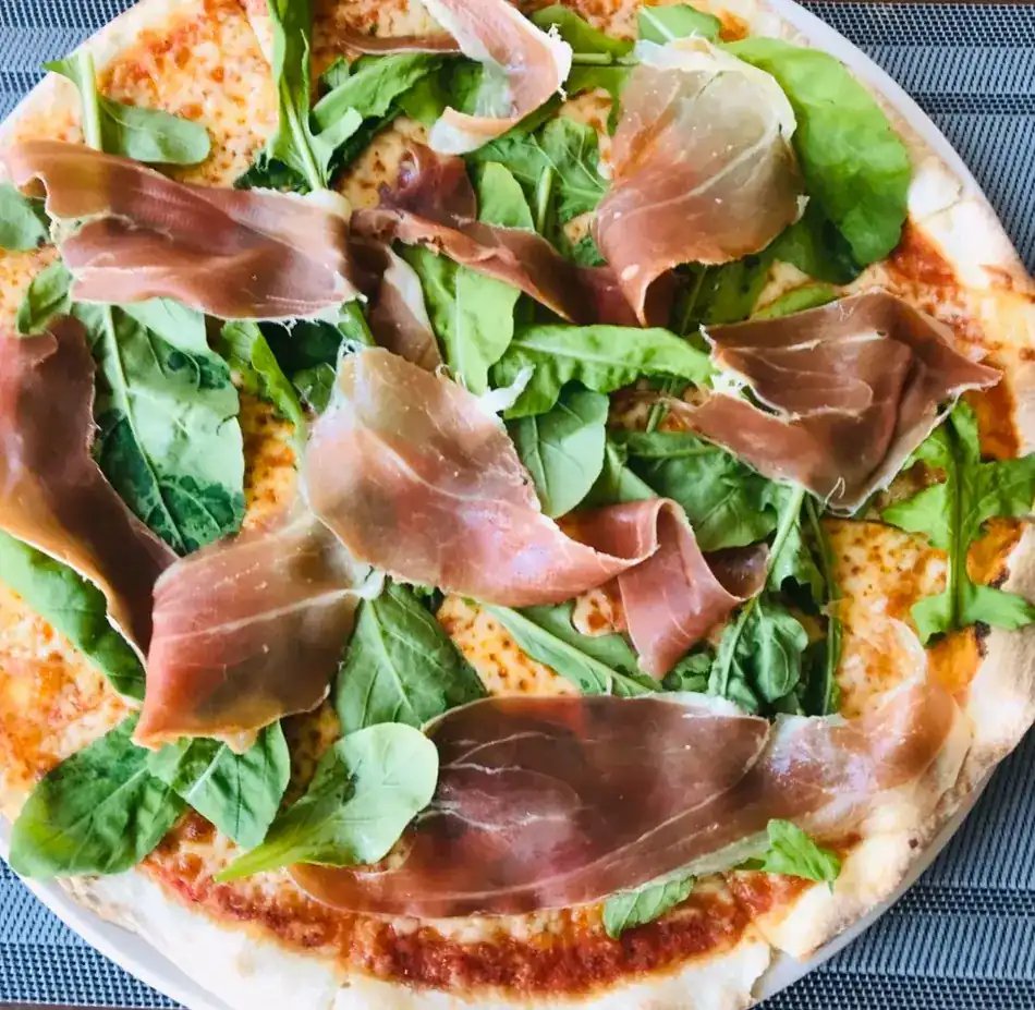 Pizza topped with rocket and Parma ham