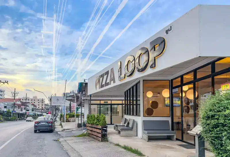 The white Loop building on Surin Beach Road, with PIZZA LOOP in large letters above the glass front