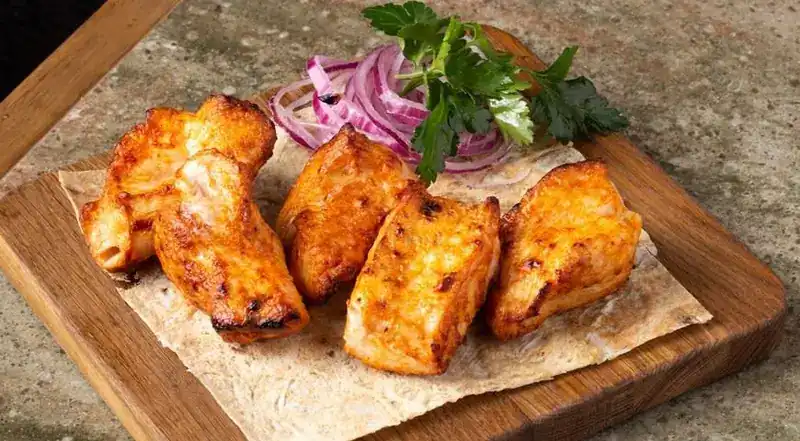 Chicken kebab on flatbread with red onion and parsley