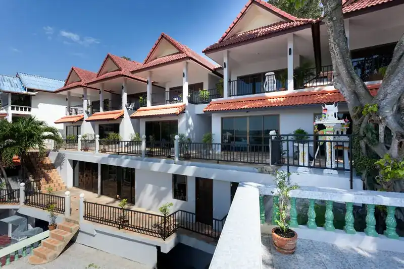 Two Chefs Inn seen from its terrace: white buildings with red tiled roofs and balconies under a blue sky